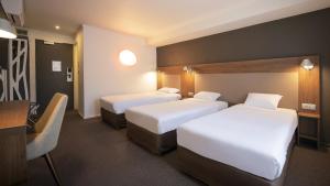 沙特尔Campanile Chartres Centre - Gare - Cathédrale的有两张床和一张书桌的酒店房间