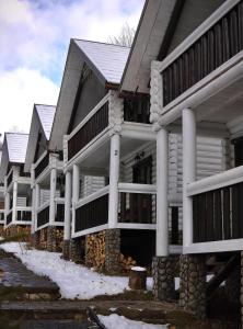 una fila de casas con nieve en el suelo en База відпочинку Forest Stream, en Svalyava