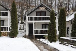 a white house with a sign on the front of it at База відпочинку Forest Stream in Svalyava