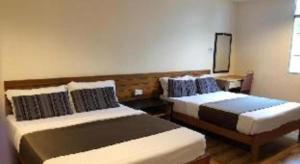 ein Schlafzimmer mit zwei Betten in einem Zimmer in der Unterkunft Hotel Sarina in Mukah