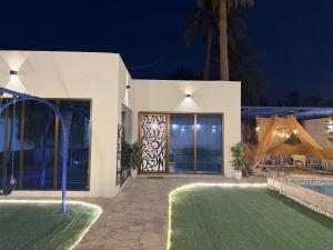 una villa con piscina por la noche en شاليه رويال دايموند, en Al-Hasa