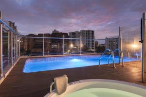 eine Badewanne auf einem Balkon mit Blick auf die Stadt in der Unterkunft Hampton by Hilton Cali in Cali