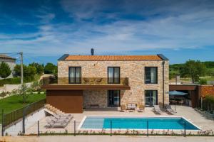 a villa with a swimming pool and a house at Villa Moia by Villas Guide in Kaštelir