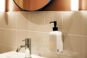 ein weißer Seifenspender auf einem Waschbecken im Badezimmer in der Unterkunft Scandic Go, Grensen 20 in Oslo