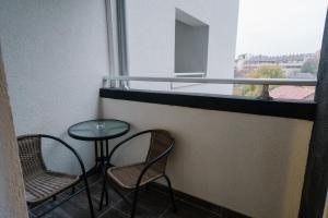 NAR Royalton Deluxe Apartment #40 في نيشْ: شرفة مع كرسيين وطاولة ونافذة