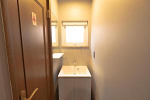 a bathroom with a white sink and a window at B cycle ダブルルーム in Biei +35 photos