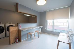 a kitchen with a counter with chairs and a washer and dryer at B cycle ダブルルーム in Biei