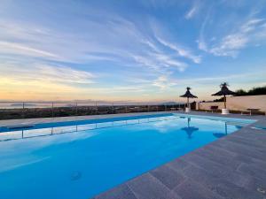 a large swimming pool with a view of the ocean at Villa Demirà - Boutique Rooms & Panoramic Pool in Marsala