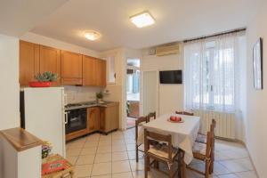 a kitchen with a table and chairs and a kitchen with a refrigerator at Appartamento Lentisco Centro by ElbaSummer in Marina di Campo