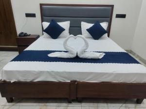 two white swans making a heart shape on a bed at Hotel Eden La in Dera Bassi +3 photos
