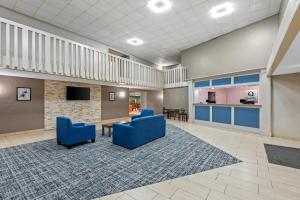 eine große Lobby mit blauen Stühlen und einem Tisch in der Unterkunft Quality Inn in West Des Moines