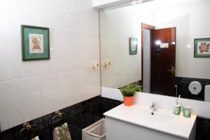 a bathroom with a sink and a mirror at GranVia Fira Apartment in Hospitalet de Llobregat +32 photos