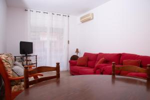 a living room with a red couch and a table at GranVia Fira Apartment in Hospitalet de Llobregat