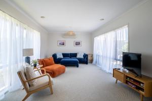 a living room with a blue couch and a tv at Bright & Spacious Getaway on Powell Street in Ocean Grove