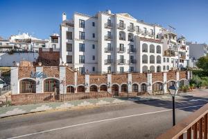 a large white building on the side of a street at Hotel Villa Frigiliana in Frigiliana