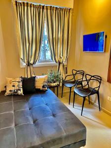 Una sala de estar con un gran sofá azul y sillas. en Cozy, comfortable ocean view apartment for 4 people, en Santos