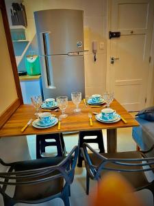 una mesa de madera con platos y vasos. en Cozy, comfortable ocean view apartment for 4 people, en Santos