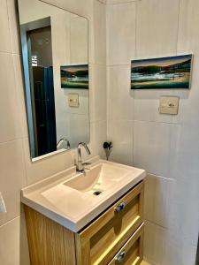 un baño con lavabo y espejo en Cozy, comfortable ocean view apartment for 4 people, en Santos