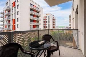 a balcony with a table and chairs and a building at Sika Jolly Apartment - cazare Arad - self check-in in Arad