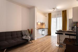 a living room with a couch and a kitchen at Sika Jolly Apartment - cazare Arad - self check-in in Arad