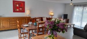 Una sala de estar con una mesa con un jarrón de flores. en Gîte les lys à Lignières Chatelain, en Lignières-Châtelain