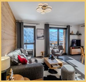 a living room with a couch and a ceiling fan at L'évasion I T3 I Les Gets in Les Gets