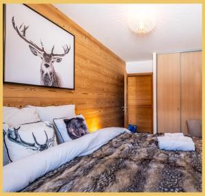 a bedroom with a bed with a picture of a deer on the wall at L'évasion I T3 I Les Gets in Les Gets