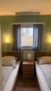 two beds in a small room with a window at Ferienhaus Drossel am Teutoburgerwald in Lage