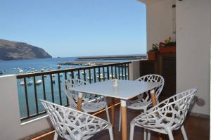 un tavolo e sedie su un balcone con vista sull'acqua di Apt. Stella Playa a Valle Gran Rey