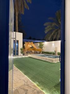 Una vista desde una puerta de un patio por la noche. en رويال دايموند, en Al-Hasa 8 fotos más