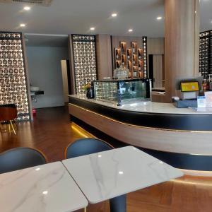 a lobby with a counter and a bar with chairs at The Rich Cafe & Hostel in Pattaya South