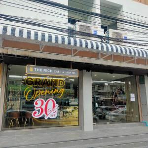 a store front with a sign in the window at The Rich Cafe & Hostel in Pattaya South