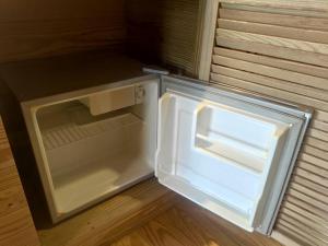 Island Paradise Resort Club في كورور: ثلاجة فارغة وبابها مفتوح في مطبخ