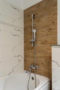 a bathroom with a tub and a shower with wood at Sika Jolly Apartment - cazare Arad - self check-in in Arad +25 photos