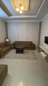a living room with a couch and a table at شقة ثلاثة غرف نوم وصالة in Al Baha