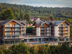 an apartment complex in the mountains with trees at Happy Valley Resort Szklarska Poręba in Szklarska Poręba