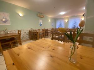 a dining room with a table with a vase of flowers on it at Hotel Ferihegy in Vecsés