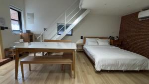 a bedroom with a bed and a desk and a staircase at 鹿厝回家-包棟民宿 in Lugang