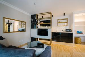 NAR Royalton Deluxe Apartment #63 في نيشْ: غرفة معيشة مع أريكة وتلفزيون