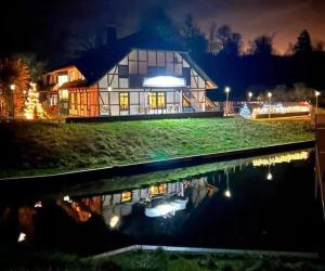 马尔肖Hotel & Restaurant Lenzer Krug的夜晚在游泳池里反射的房屋