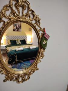 a mirror on a wall with a bed in a room at Apartman Raj in Vrnjačka Banja