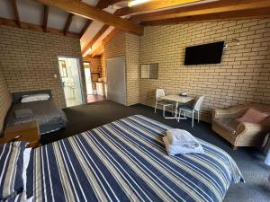 a bedroom with a bed and a tv and a table at Nannup Hotel Motel in Nannup