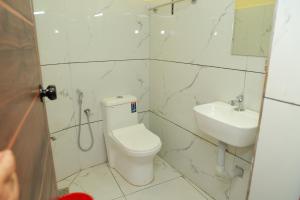 a white bathroom with a toilet and a sink at SJ Homes in Karukachal +24 photos