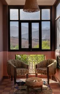a living room with two couches and a large window at Atlas Aura Hotel Ourika - Marrakech in Agadir nʼTafent +66 photos