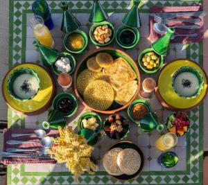 a table with plates of food and bowls of food at Atlas Aura Hotel Ourika - Marrakech in Agadir nʼTafent