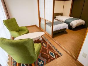 a room with a bed and two chairs and a mirror at Family Villa KASAMA - Vacation STAY 42429v in Kasama