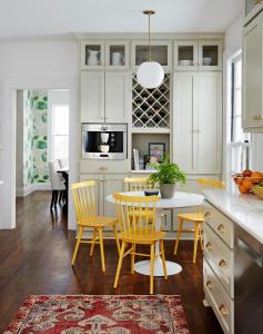 a kitchen and dining room with yellow chairs and a table at Yellow listing in Praveshka Lakavitsa