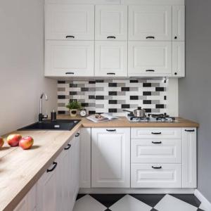 a kitchen with white cabinets and apples on a counter at Yellow listing in Praveshka Lakavitsa