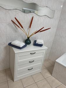 Un baño con una cómoda blanca con un jarrón encima. en Ferienwohnung Steinstübchen, en Bautzen 6 fotos más