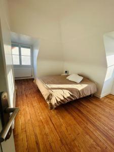 una cama en una habitación con suelo de madera en Maison à la Campagne, 